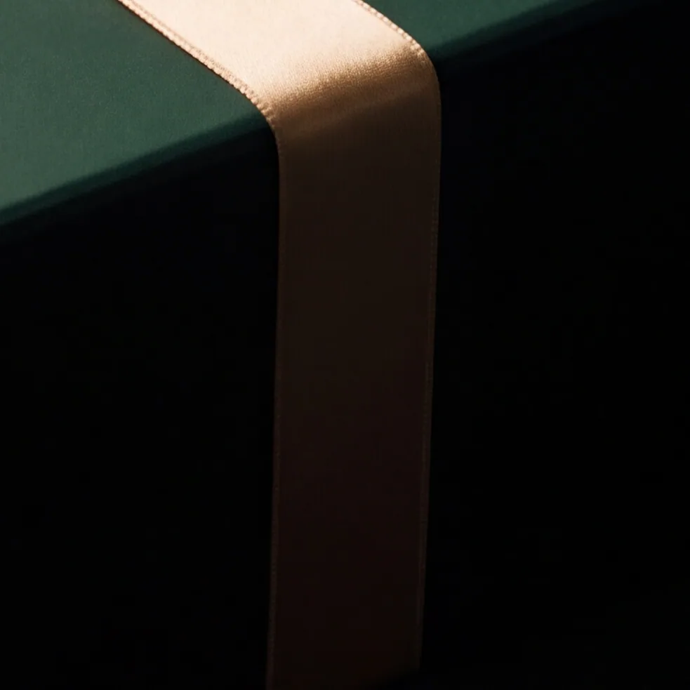 A length of gold satin ribbon lying in loose folds.